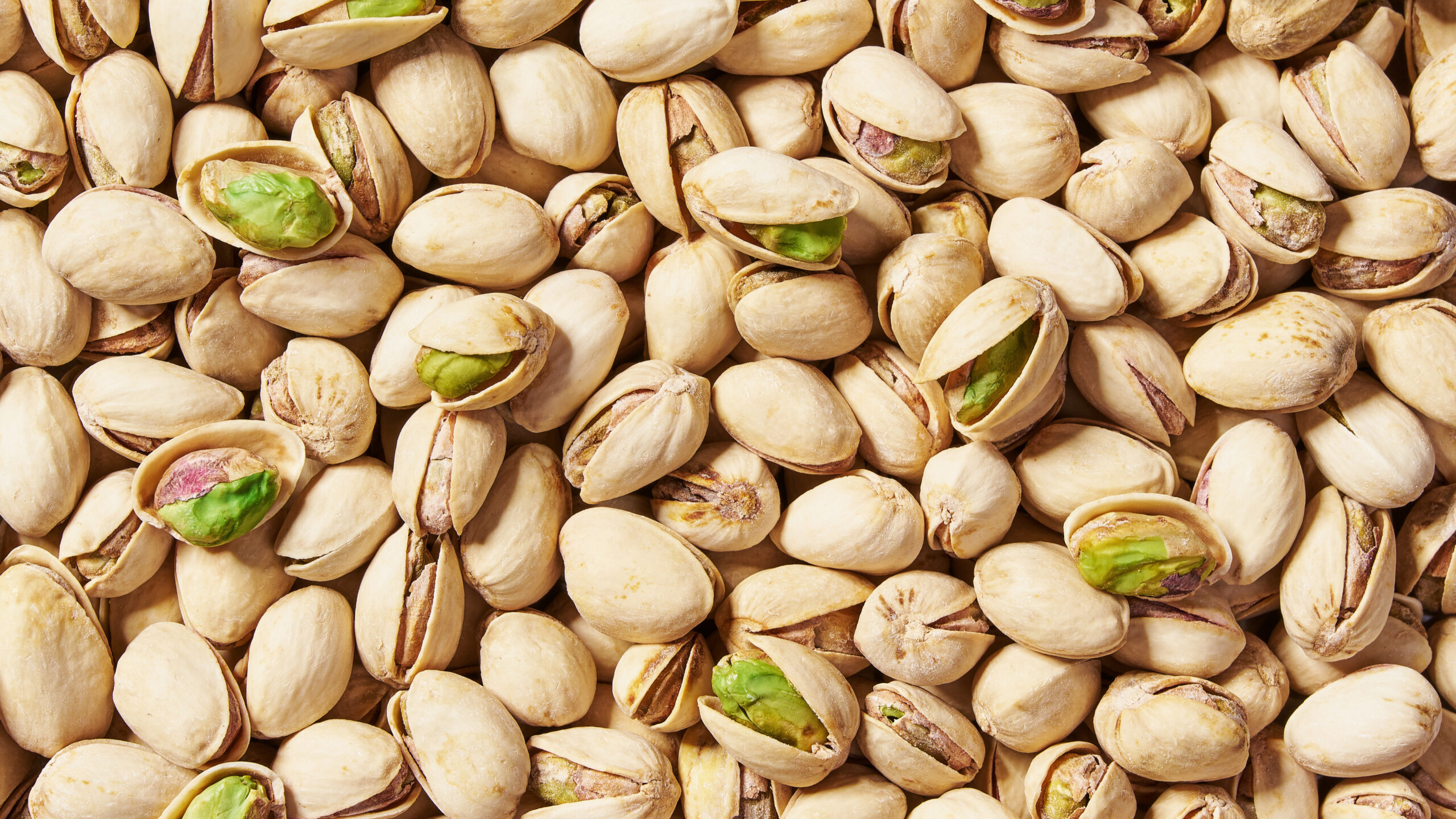 A stack of whole and cracked pistachios, representing the successful agricultural and marketing blueprint that the American chestnut industry is working to follow.