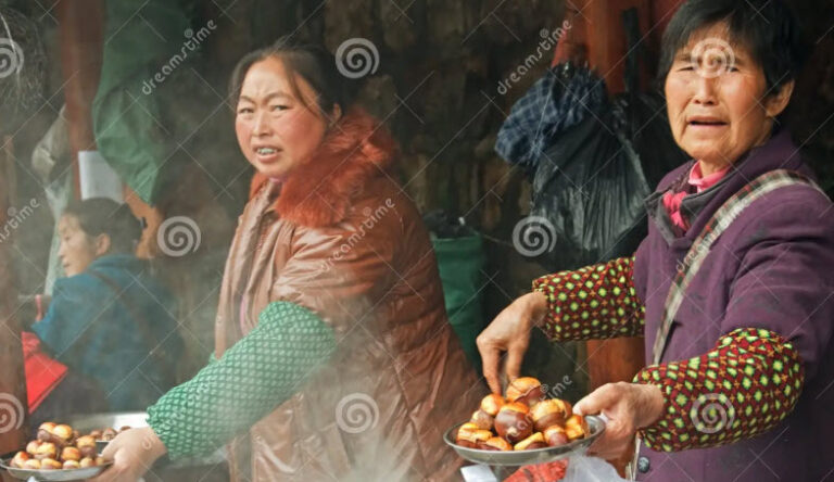 Eating chestnuts. Asian vendor roasting chestnuts at a winter street market