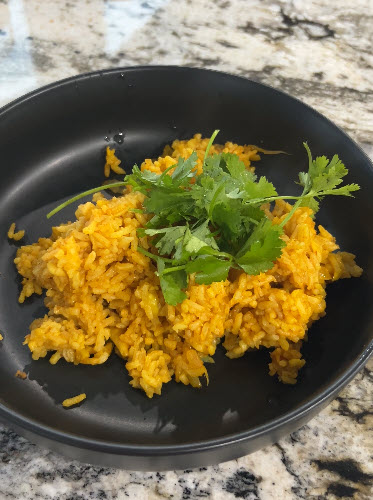 Spanish rice as a side to carnitas with chestnut mole sauce.